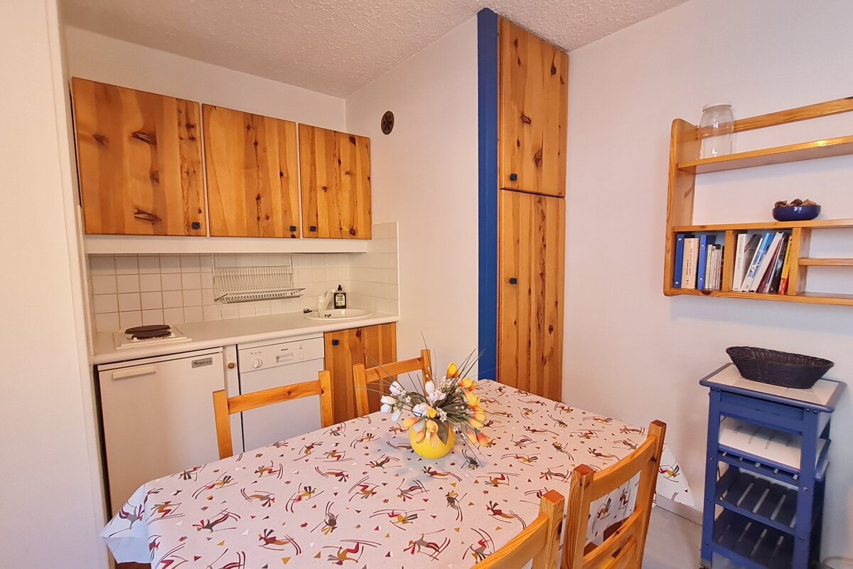 A kitchen with a table and chairs and a dishwasher