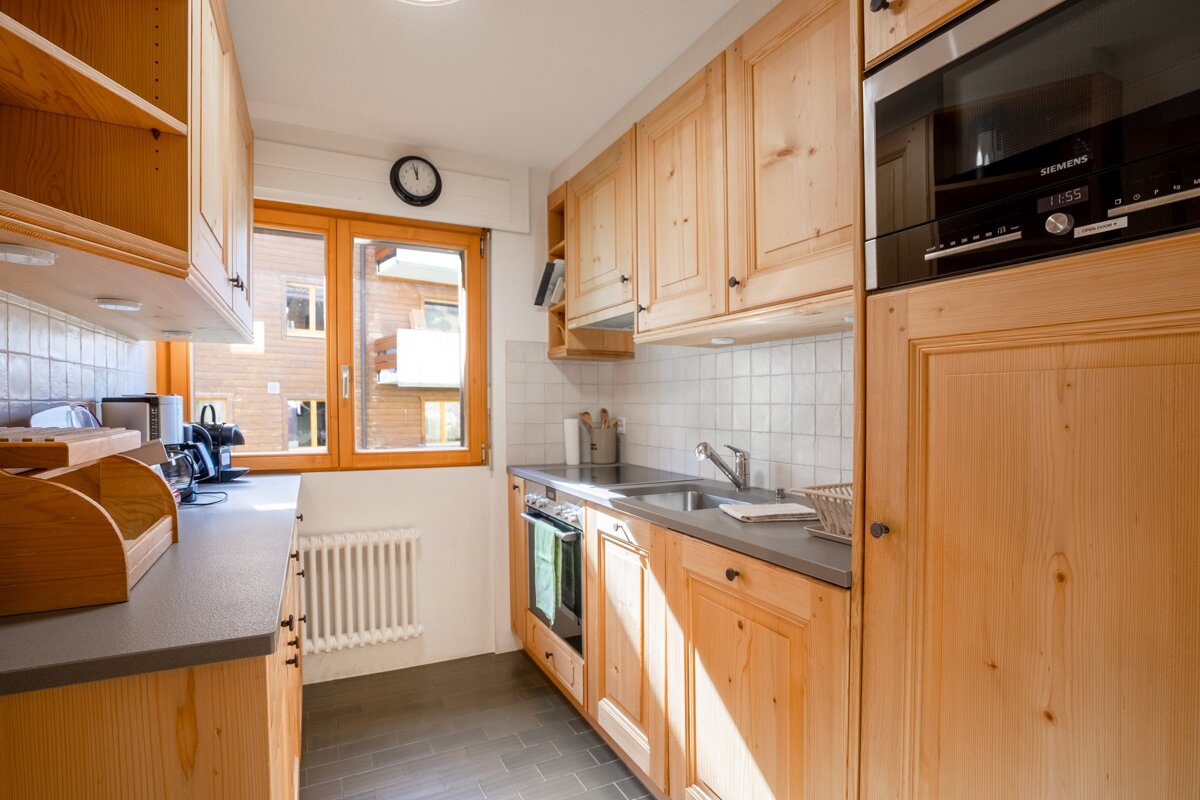 A kitchen with wooden cabinets and a siemens microwave