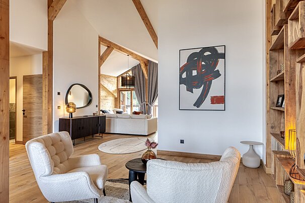 A living room with two chairs and a painting on the wall