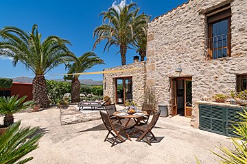 A stone building with a table and chairs in front of it