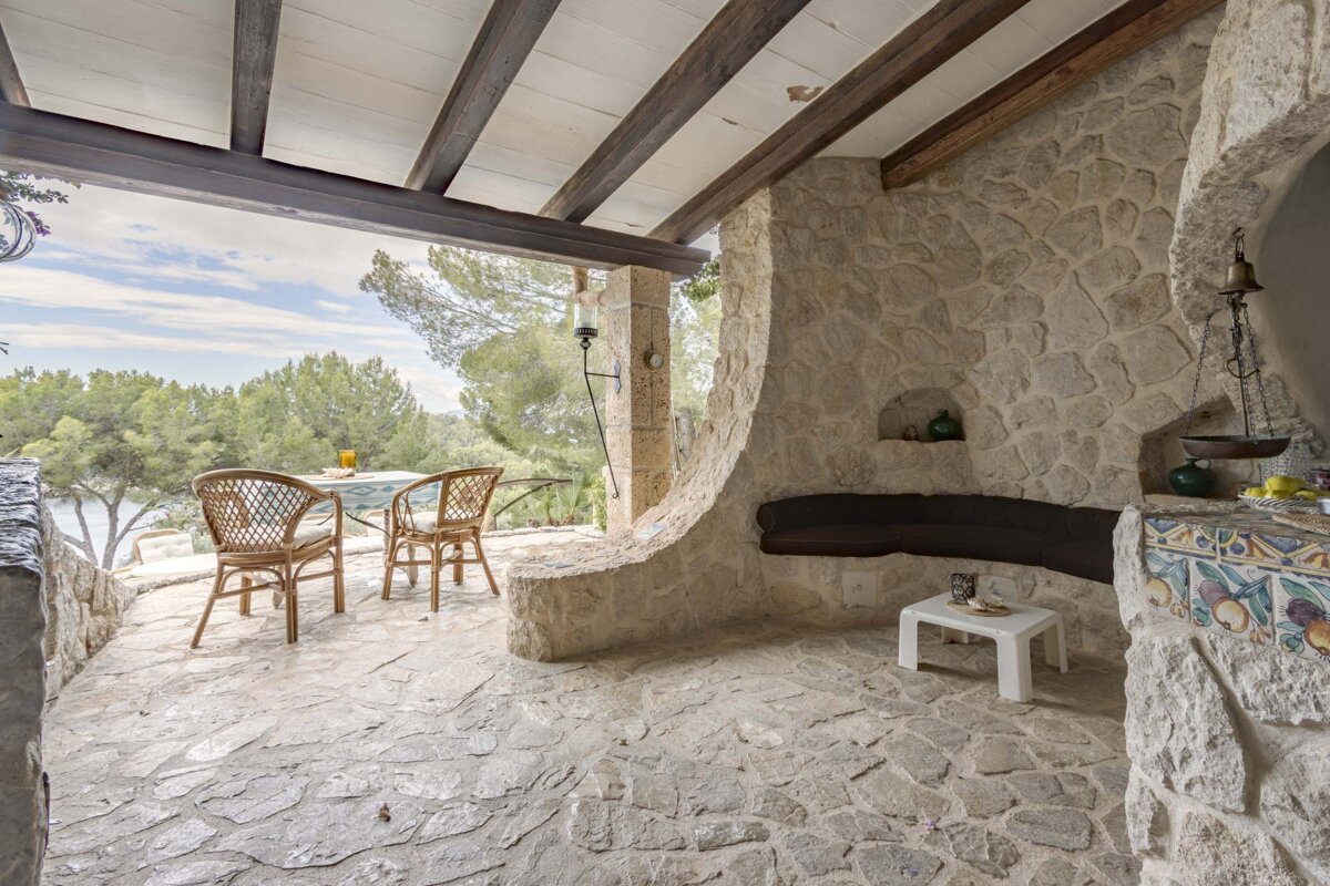 A stone patio with a table and chairs on it