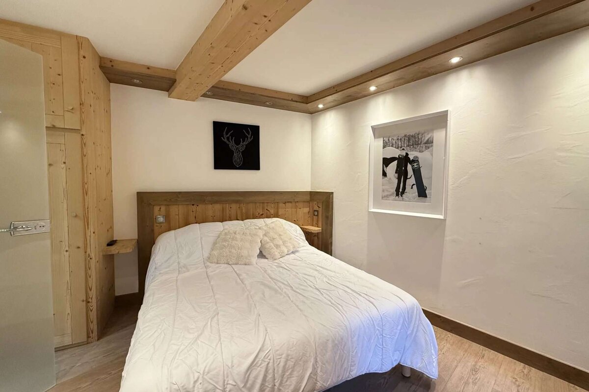 A bedroom with a bed and a picture on the wall
