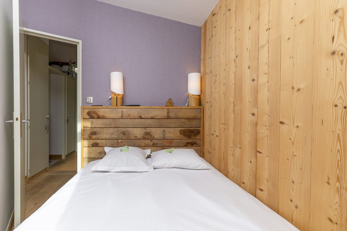 A bedroom with purple walls and wood paneling