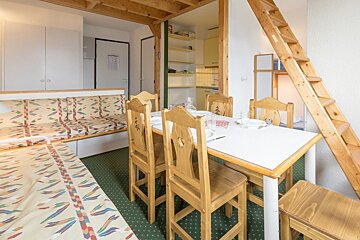 A living room with a table and chairs and a staircase