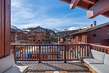 A balcony with a view of mountains and buildings