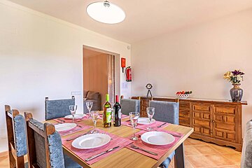 A bottle of wine sits on a table in a dining room