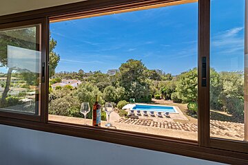 A window with a view of a pool and trees
