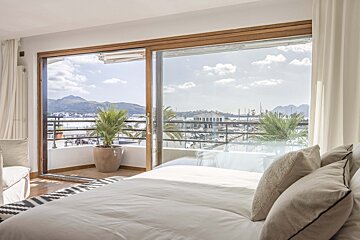 A bedroom with a sliding glass door leading to a balcony