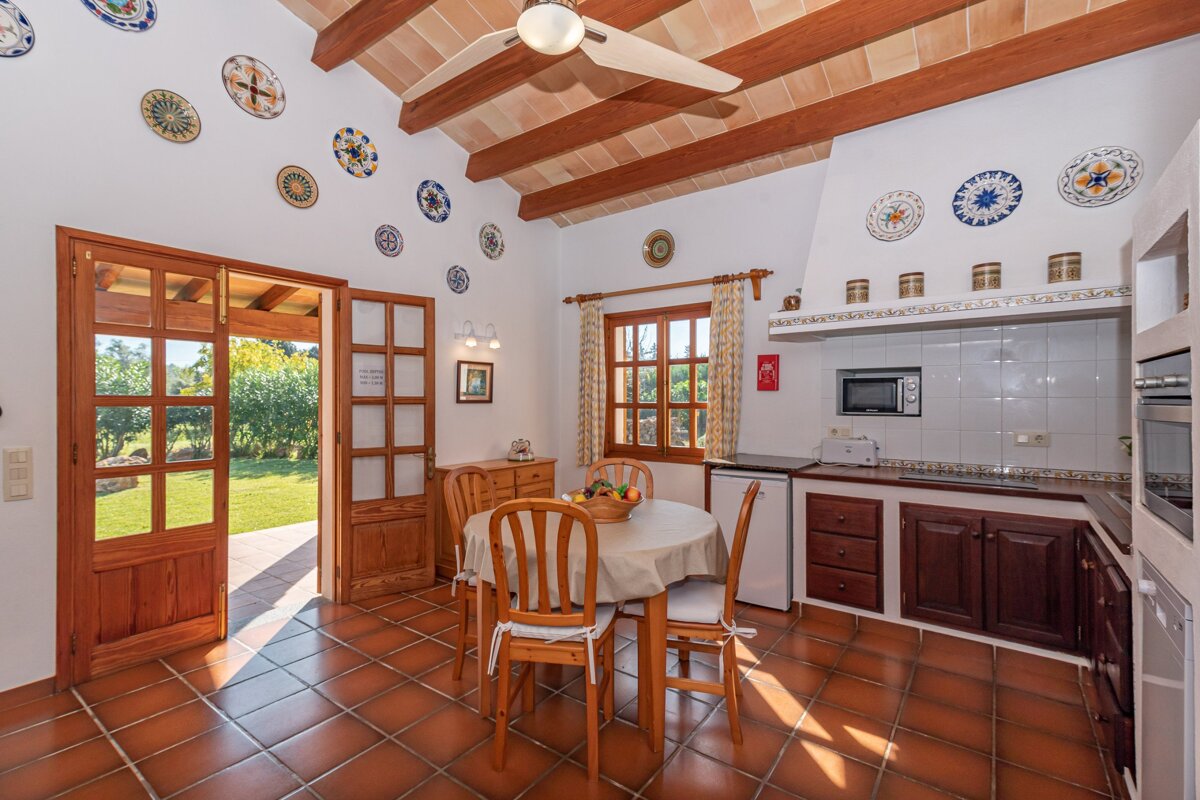 A kitchen with a table and chairs and plates on the wall