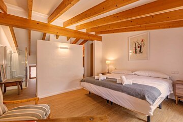 A bedroom with a large bed and a picture on the wall