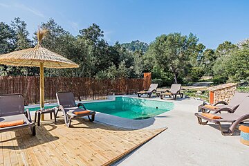 A swimming pool surrounded by chairs and an umbrella