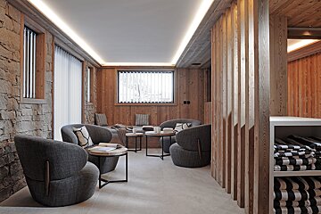 A room with chairs and tables with striped towels on a shelf