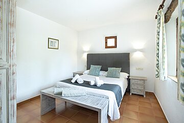 A bedroom with a large bed and two nightstands