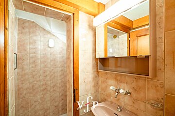 A bathroom with a sink and a mirror with the letter v on it