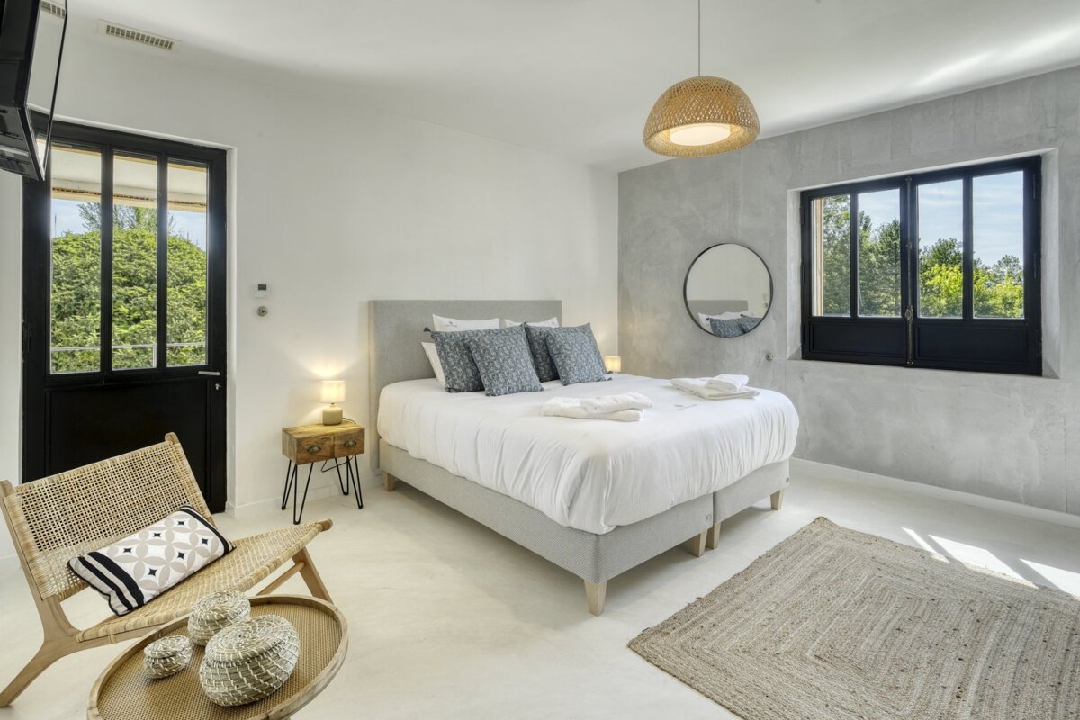 A bedroom with a large bed and a chair