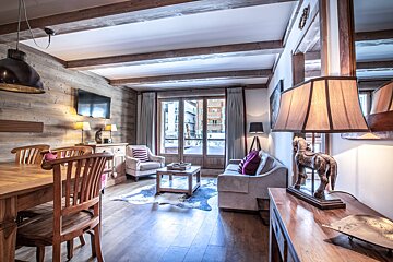 A living room with a couch a table and chairs