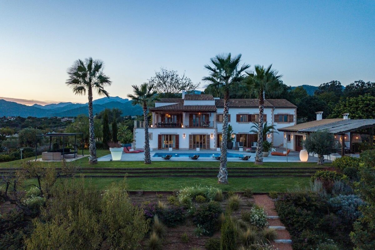 A large white house with palm trees in front of it