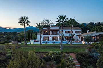 A large white house with palm trees in front of it