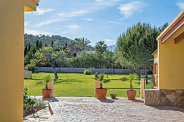 A patio with potted plants in front of a house