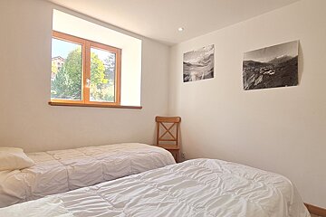 A bedroom with two beds and two pictures on the wall