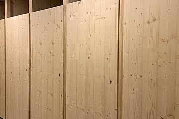 A wooden wall with a few holes in it