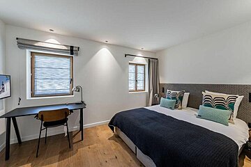 A bedroom with a large bed and a desk