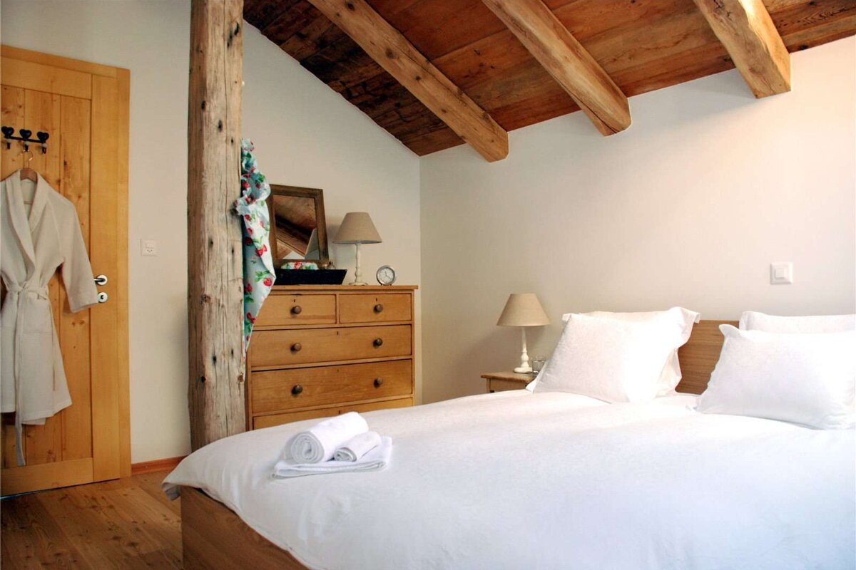 A bedroom with a bed dresser and a mirror