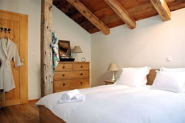 A bedroom with a bed dresser and a mirror