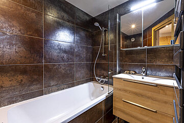 A bathroom with a bathtub a sink and a mirror