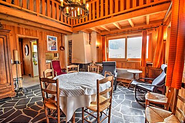 A living room with a table and chairs and a fireplace