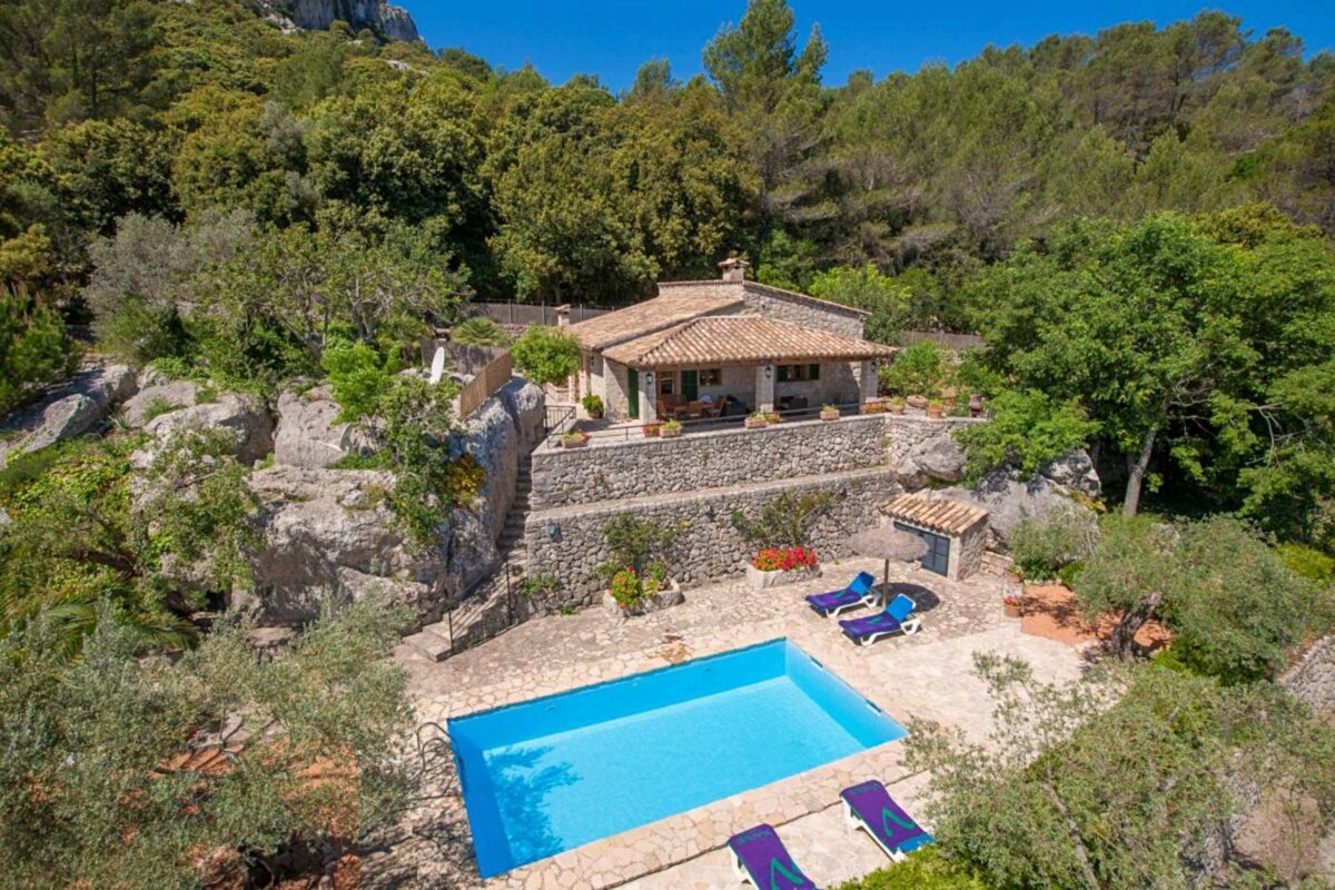 An aerial view of a house with a large swimming pool