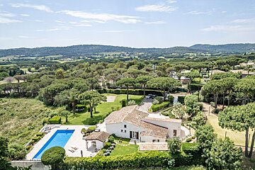 An aerial view of a house with a large swimming pool