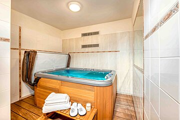 A hot tub in a bathroom with the cover up