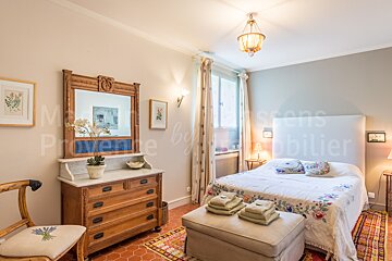 A bedroom with a bed and a dresser with provence written on the wall