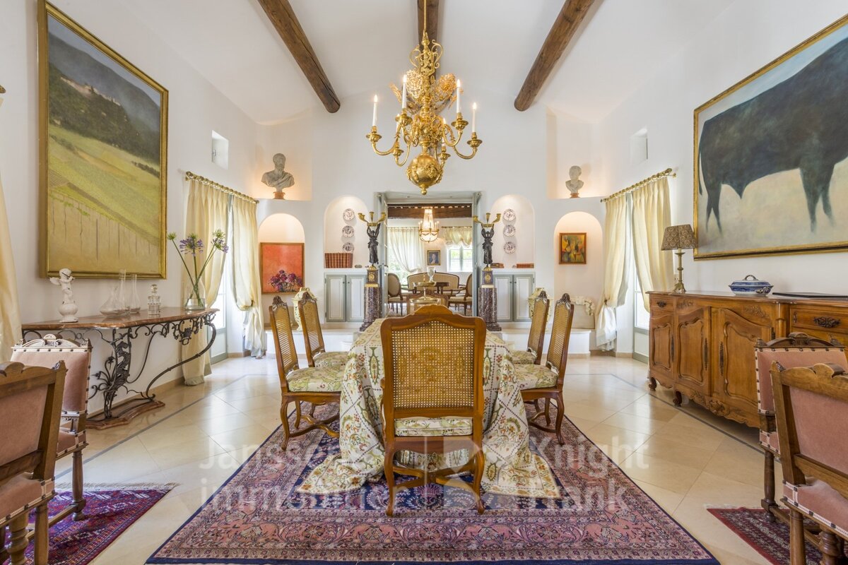 A dining room with a chandelier and a painting of a bull on the wall