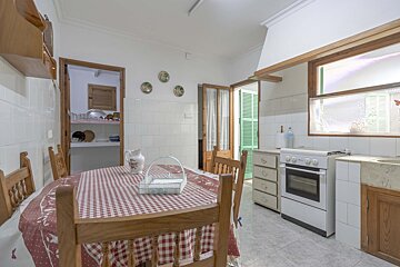 A kitchen with a table and chairs and a stove