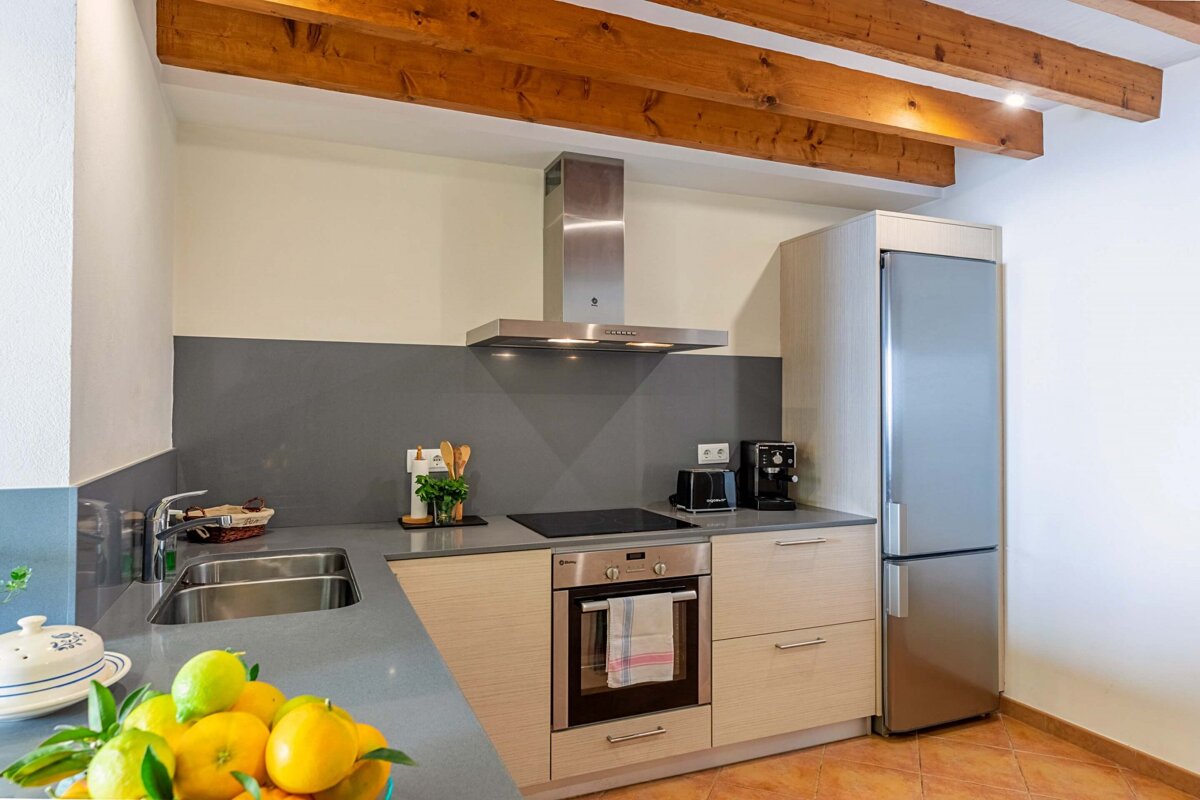 A kitchen with a stove top oven and a stainless steel refrigerator