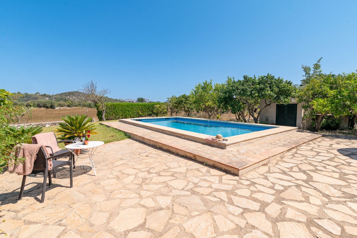 A swimming pool with a table and chairs in front of it