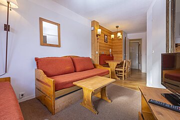 A living room with a couch a table and a television