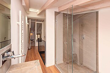 A bathroom with a walk in shower and a sink