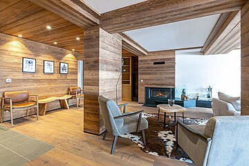 A living room with wood paneling and a fireplace