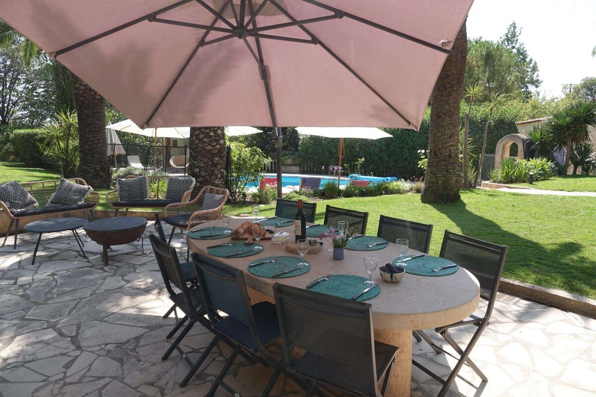 A patio with a table and chairs under an umbrella