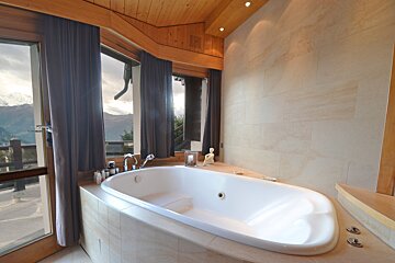 A bathtub in a bathroom with a view of the mountains