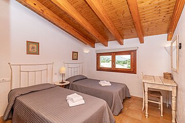 A bedroom with two twin beds and a wooden ceiling