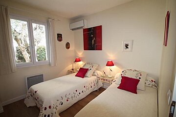 A bedroom with two beds and a painting on the wall