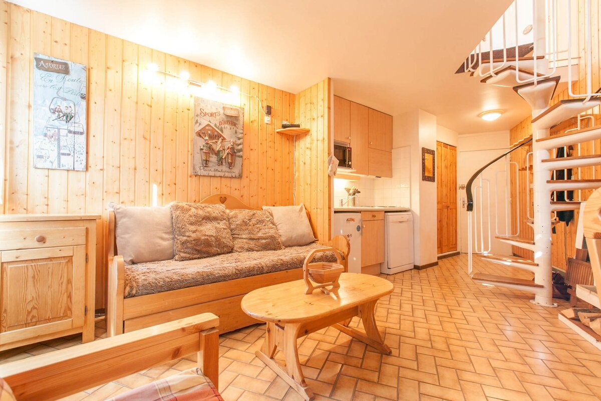 A living room with a spiral staircase and a sign that says agence