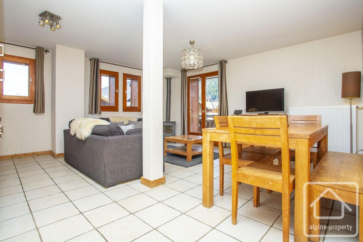 A living room with a dining table and chairs and a sign that says alpine property
