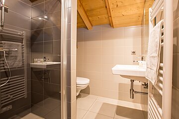 A bathroom with a toilet a sink and a shower
