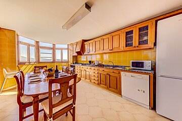 A kitchen with a table and chairs and a microwave
