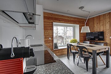 A kitchen with a table and chairs and a window
